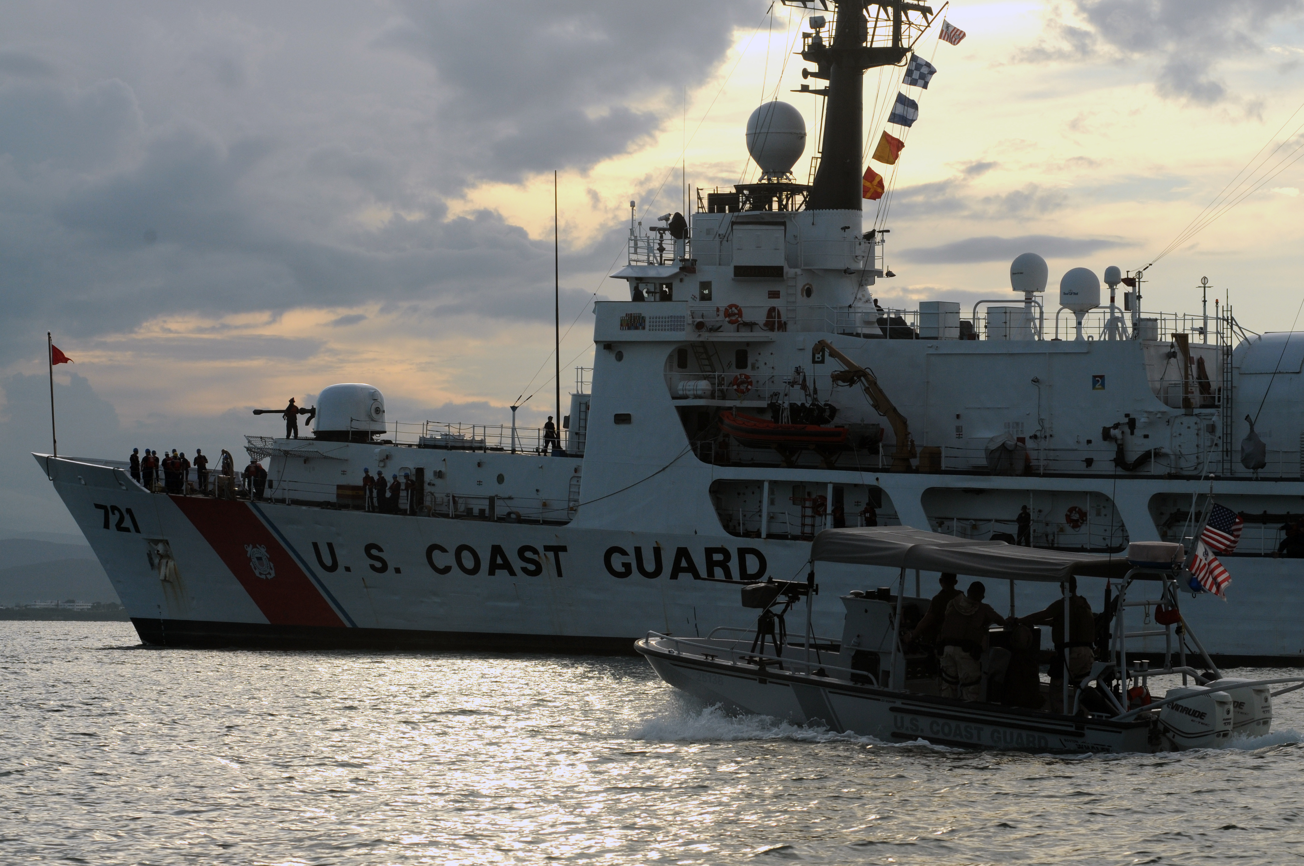 This is an image of a U.S. Coast Guard patrol boat escorting a U.S. Coast Guard cutter.